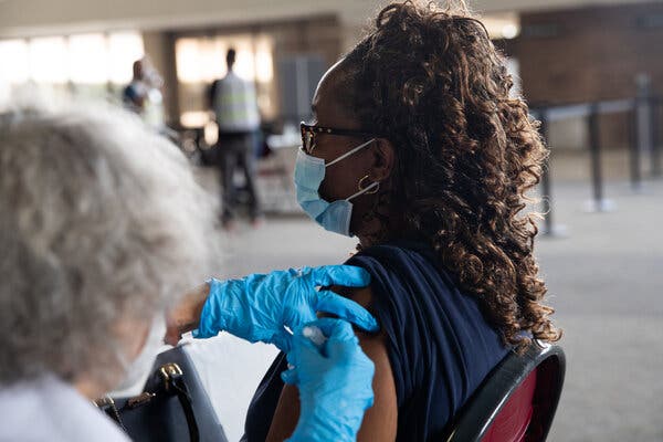 A patient receives their booster dose of the Pfizer-BioNTech coronavirus vaccine in Southfield, Mich., on Monday.