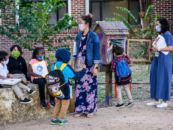 Students and teachers wearing their school-required masks wait for parents to arrive outside Lamar Elementary School in San Antonio, Tx.
