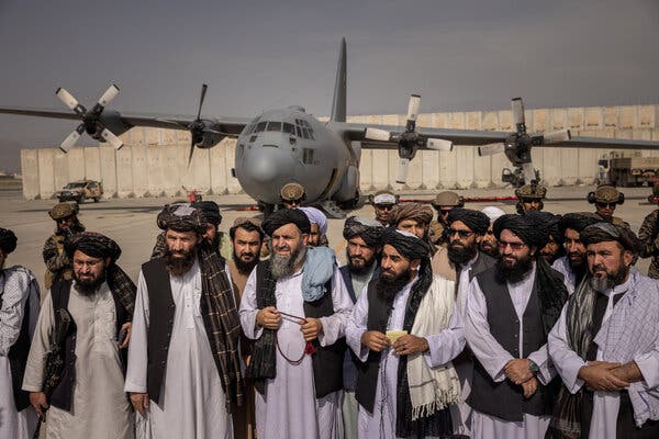 Taliban officials, including Zabihullah Mujahid, third right, announcing victory at the airport in Kabul, Afghanistan, on Tuesday.
