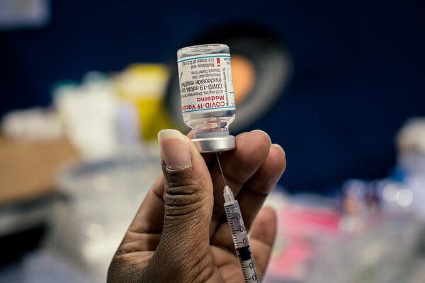 A staff member at a vaccination center prepares a vial of the Moderna Covid-19 vaccine.