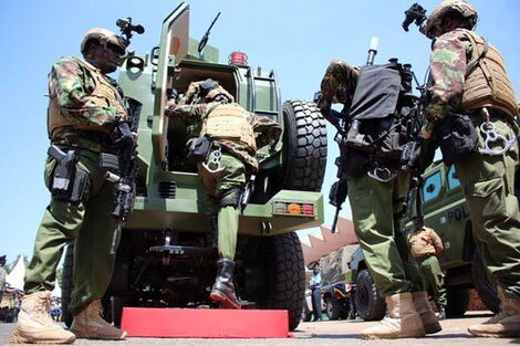 A file image of police officers hoping into an Armoured vehicle
