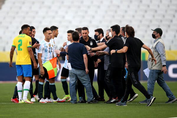 Brazilian health officials argue with Lionel Scaloni, the head coach of Argentina, center, as play is halted during the Brazil-Argentina match.