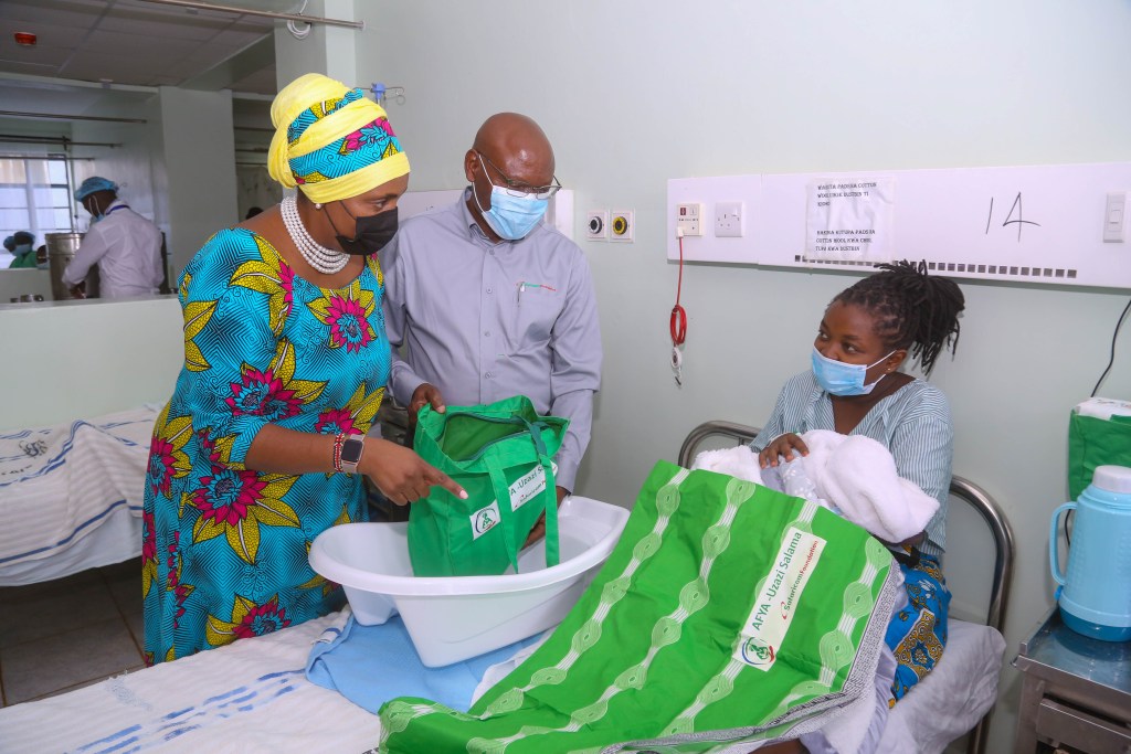 Deputy Governor, Nyeri County, Dr Caroline Karugu (L) and Safaricom Foundation Chairman, Joe Ogutu(C) hands over Mama and Baby pack to a new mother, Josephine Kang’ata during Safaricom Foundation’s handover of a Maternal HDU and Newborn unit in KNH Othaya, Nyeri County - Bizna Kenya