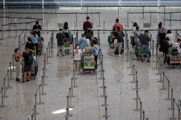 Waiting for shuttle buses to mandatory government-designated quarantine hotels in the arrival hall at the Hong Kong International Airport on Tuesday.