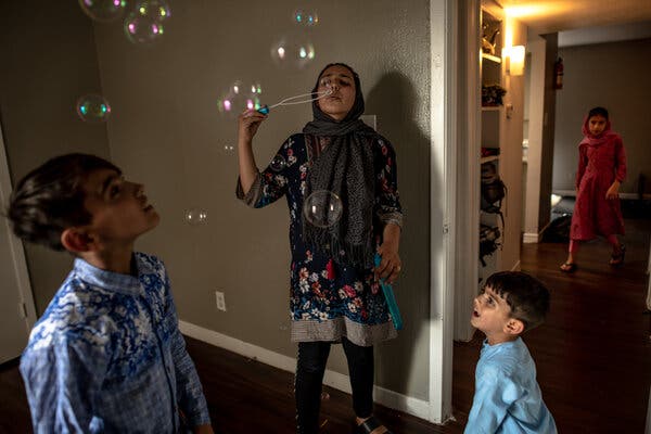 Brishna Yousafzi, center, blowing bubbles with her brothers Huzzaif, left, and Murtaza.
