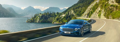 A Bentley Continental GT car speeding on a highway.
