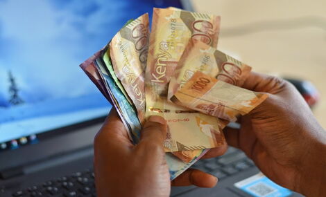 An image of a man holding a stash of cash