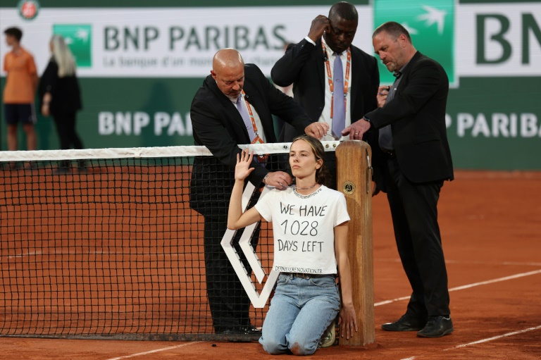 French Open semi-final interrupted after environmental activist ties herself to net in protest