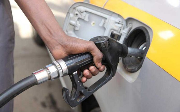 A motorist fuels at a petrol station. A motorist fuels at a petrol station.