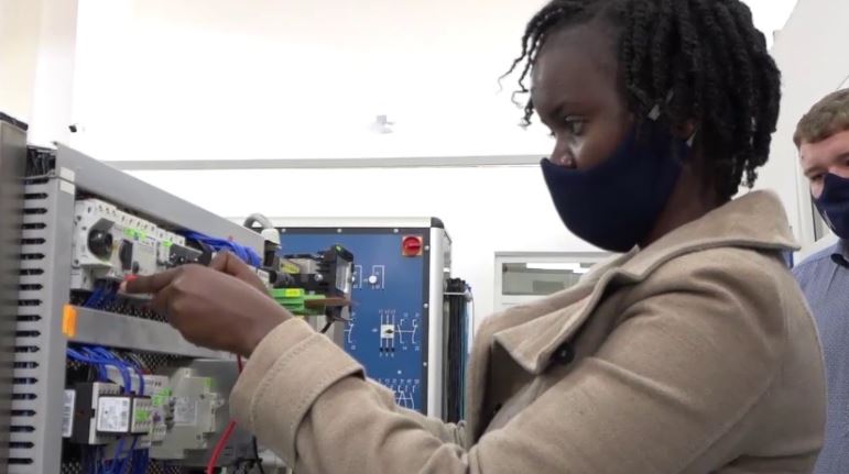 Mary Maina, a Mechatronics Technician who recently graduated from the apprenticeship programme conducted by Krones East Africa, troubleshoots using a multi-meter equipment used to measure electric current. Looking on is Henning Post, the Head of Training at Krones (Photo: Courtesy)