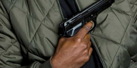 An undated photo of a person holding a gun.