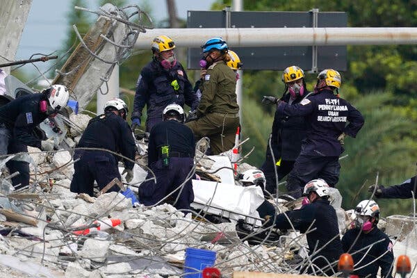 Workers in Surfside, Fla., prepared to remove a victim from the rubble on Monday. Four more bodies were found, bringing the confirmed death toll to 28.