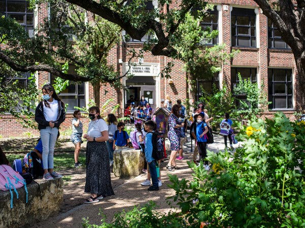 Students and teachers wearing their school-required masks wait for parents to arrive outside Lamar Elementary School in San Antonio, Texas.