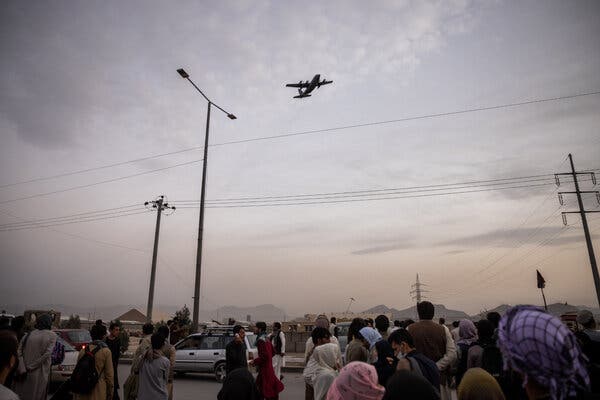 A crowd of people trying to flee Afghanistan lining up outside Kabul’s airport as a military cargo plane took off on Friday.