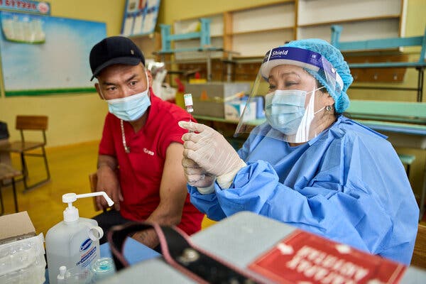A healthcare worker prepared a vaccine dose at a vaccination site in Ulaanbaatar, Mongolia as the dose’s recipient watched, last week.