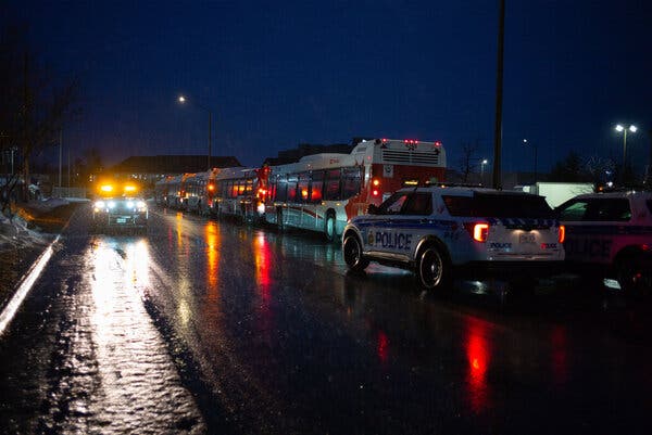 Police vehicles and municipal buses at a convention center near the airport in Ottawa. 