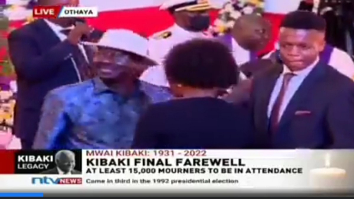 Shock as Kibaki’s Grandson Refuses to Greet Raila at Burial, Hides His Face From Him